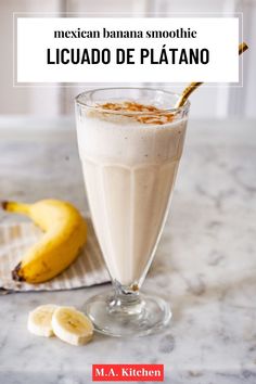 a banana smoothie in a glass next to some sliced bananas