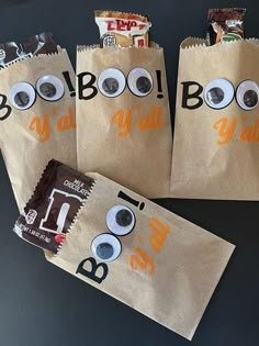 three brown bags with googly eyes and eyeballs on them sitting on a table