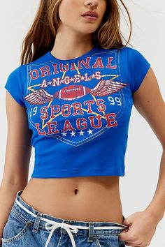 Original Angles Sports League baby tee. Shrunken fit graphic tee with a sportsball graphic at the front. Washed soft and faded graphic for a vintage vibe. Features Original Angles Sports League baby tee Sports graphic baby tee Vintage washed and faded Cropped fit UO exclusive Content + Care 100% Cotton Machine wash Imported Size + Fit Model in Blue is 5’8" and wearing size Small Measurements taken from size Small Chest: 24" Length: 19" | Original Angles Sports League Baby Tee in Blue, Women's at Urban Outfitters Urban Outfitters Blue Tops With Graphic Print, Baby Tees Outfit, Vintage Graphic Print Tops Urban Outfitters, Urban Outfitters Sporty Streetwear Tops, Urban Outfitters Baby Tee, Butterfly Graphic Tee, Romantic Blue Baby Tees, 8th Grade Outfits, Usa Tee