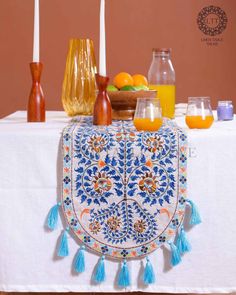 a table topped with candles and fruit on top of a white cloth covered tablecloth