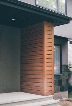 the front door of a house with wooden slats on it's side and steps