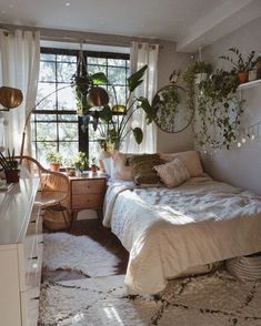 a bed room with a neatly made bed and lots of plants