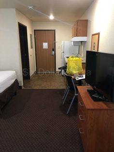 a hotel room with a bed, desk and television