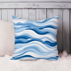 a blue and white pillow sitting on top of a furnishing next to a wooden headboard