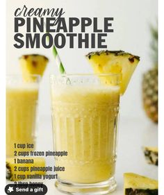 a pineapple smoothie in a glass with a straw and two pieces of pineapple on the side