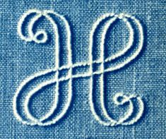 the letter s is made out of blue fabric with white stitching on it's edges