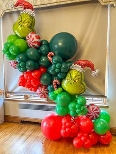 an assortment of balloons in the shape of grin's head and candy canes