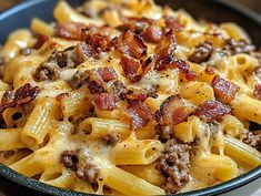 a bowl filled with pasta covered in cheese and bacon