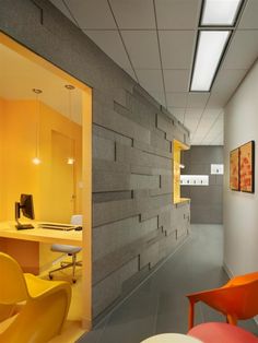 an office with yellow chairs and gray walls