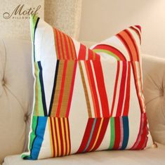 a multicolored striped pillow on a white background