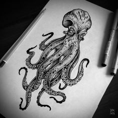 an octopus drawing on paper next to two markers and a pen with the ink in it