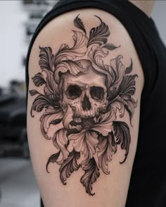 a skull and flower tattoo on the left upper half of the arm, which is black and white