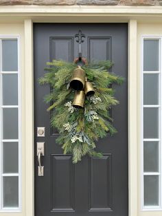 a christmas wreath with bells hanging on the front door