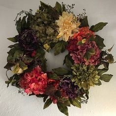 a wreath with flowers hanging on the wall