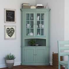 a green china cabinet with glass doors and shelves