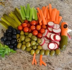 a platter filled with sliced vegetables and olives, carrots, celery, radishes, and pickles