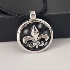 A high-quality Sterling silver pendant. ⚜   Fleur de Lis mans silver pendant. 🔳 Round gothic style, man-size but not only,  ⚔   knights pendant, strong and beautiful form a 925 sterling-silver item you will adore.  📜 Handmad engraved Fleur De Lis symbols on top and on the two bands, special        handcraft black patent finishing. Hard hand-polished piece!  ⚖ Weight.9.0grs ✍ Designed and created by Babuco Jewellery Athens. ♻ A recycled item. 💍 Best gift for you!  🎁 Box included!v 😊 Thanks for stopping by! ✈ Do You need faster shipping? Purchase EXPRESS SHIPPING also from my listings! 🛠   Free services to renew your beloved jewels purchased from my shop.          You will charge only for the shipping costs. Gothic Silver Necklace With Round Pendant, Silver Gothic Round Pendant Necklace, Silver Gothic Necklace With Round Pendant, Gothic Sterling Silver Necklaces In Silver, Gothic Sterling Silver Necklaces, Handmade Medieval Silver Necklaces, Gothic Silver Round Necklace, Silver Gothic Round Necklace, Medieval Sterling Silver Necklace In Silver