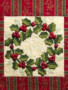 a quilted christmas wreath with holly leaves and red berries on the center is shown