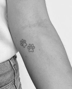 a small paw tattoo on the left arm