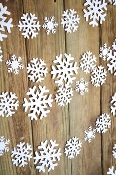 white snowflakes are arranged on a wooden surface