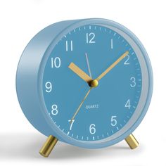 a blue alarm clock with gold hands on a white background