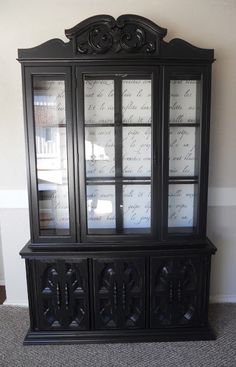 an old black china cabinet with glass doors