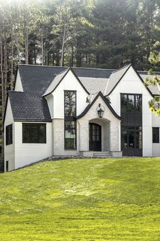 a large white house with black roof and windows