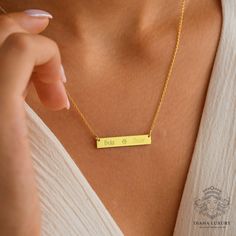 The Personalized Name Bar Necklace is an elegant and minimalistic custom name necklace, perfect as a couple gift or an anniversary present. This handmade necklace features a sleek bar pendant that can be customized with names in a beautiful calligraphy font, making it a cherished couple names gift. Whether it's for a wedding gift, a graduation gift, or a bridesmaid pendant, this name necklace adds a personal and stylish touch to any occasion. Available in both gold and silver, it serves as a stunning gift pendant that combines timeless elegance with personal significance. Each necklace is meticulously crafted, ensuring it is a unique and special piece. The minimalist design makes it suitable for everyday wear or as a statement piece for special events. This customized necklace collection i Personalized Gold Bar Necklace Gift, Personalized Gold Bar Necklace As Gift, Engraved Gold Bar Necklace For Mother's Day, Personalized Gold Bar Necklace For Gift, Gold Engraved Bar Necklace For Mother's Day, Engraved Rectangular Pendant Bar Necklace As Gift, Elegant Everyday Engraved Custom Necklace, Mother's Day Engraved Gold Bar Necklace, Gold Nameplate Bar Necklace As Gift