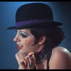 a woman wearing a black top hat and makeup