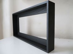 a black shelf sitting on top of a white table