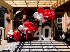 the number forty is decorated with balloons and streamers