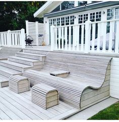 a wooden deck with steps leading up to the back door and white fence surrounding it