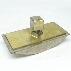 a metal object sitting on top of a white surface