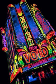 an illuminated building with neon lights on it's sides and the words, theater into void