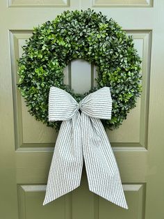 a wreath with a bow hanging on the front door