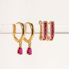 These 14K Gold Small Hoop earrings feature a tiny dangling pear shaped Ruby gemstone. With just the right amount of sparkle these go great with other huggies in our 14K Gold Collection. | Lead and Nickel free 14K Gold Ruby Cubic Zirconia Pear 5x3mm(0.2x0.12in) Hoop Inside Diameter 8mm(0.3in), Thickness 1.8mm(0.07in) Hinge closure ES056-GRB Gold Small Hoop Earrings, Gold Huggies, Colored Gemstones, Minimal Earrings, Small Hoop Earrings, Birthstone Gifts, Crystal Stones, Ruby Gemstone, Gold Collection