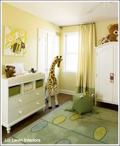 a giraffe standing in the middle of a bedroom next to a dresser and bed