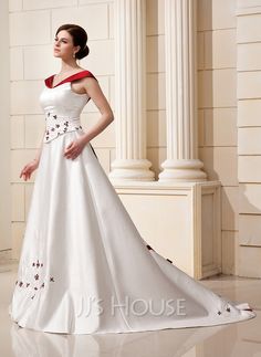 a woman in a white dress standing next to columns