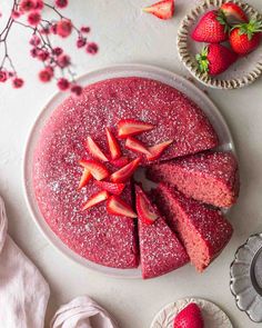 a strawberry cake with powdered sugar and sliced strawberries