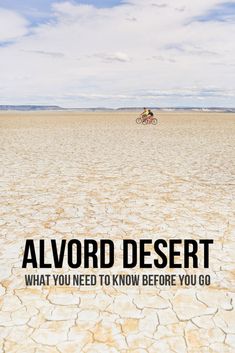 a man riding a bike across a dry grass covered field with the words, alvord desert what you need to know before you go