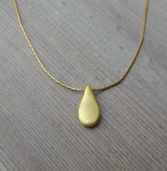 "This hand made teardrop pendant necklace has an effortless, earthy allure. The matte 18k gold plated brass pendant hangs at the base of a delicate 14k gold filled chain. This is the perfect necklace to pair with any casual outfit adding a bohemian vibe. Wear this alone, or layer it with your other favorites for a personalized eclectic look. ❉ F A C T S total length : 16\"/ 42 cm teardrop length: 1\"/ 2.54 cm teardrop width: 0.45\"/ 1.1 cm You will receive the necklace in a gift box ready to be Handmade Gold Teardrop Drop Necklace, Gold Bohemian Teardrop Pendant Drop Necklace, Bohemian Gold Teardrop Pendant Drop Necklace, Gold Drop Bohemian Necklace, Bohemian Gold Teardrop Pendant Necklace, Bohemian Gold Drop Necklace, Dainty Handmade Drop Necklace, Minimalist Handmade Teardrop Pendant Necklaces, Handmade Minimalist Teardrop Pendant Necklace