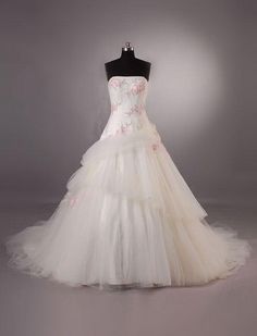 a white wedding dress with pink flowers on it