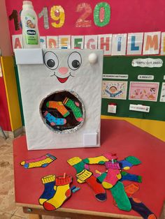 a child's artwork made out of construction paper on a table in front of a bulletin board