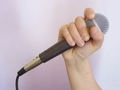 a hand holding a microphone in front of a white background with the words how to use a microphone