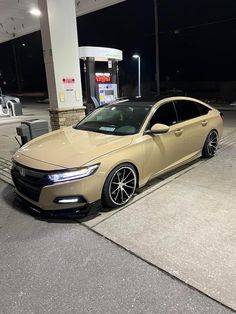 a beige car parked in front of a gas station