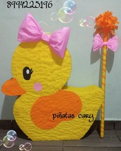 a yellow rubber ducky with a pink bow on its head and bubble wand in front of it