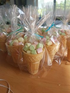 small ice cream cones wrapped in plastic wrappers on a wooden table with wires and cords