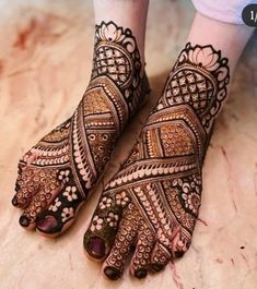 the feet and hands of a woman with henna tattoos