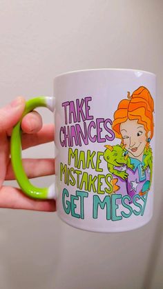 a person holding a coffee mug with the words take changes make misstakes get mess