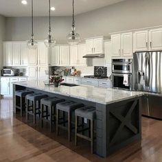 a large kitchen with white cabinets and stainless steel appliances